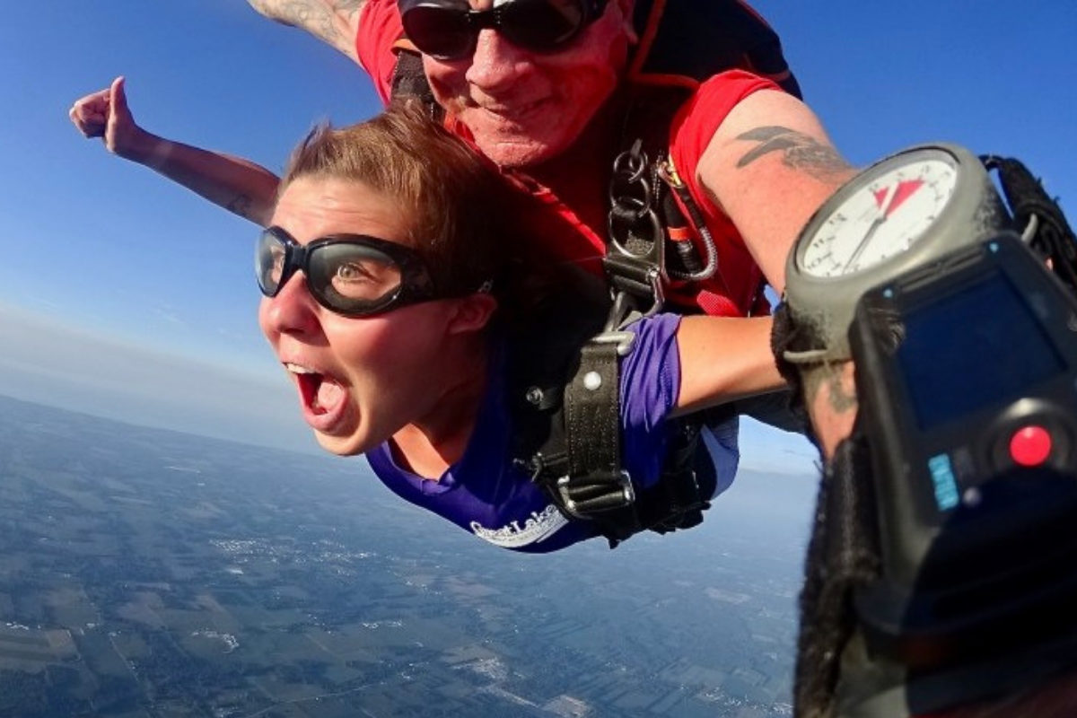 Kaila Proulx gives thumbs up skydiving the first time
