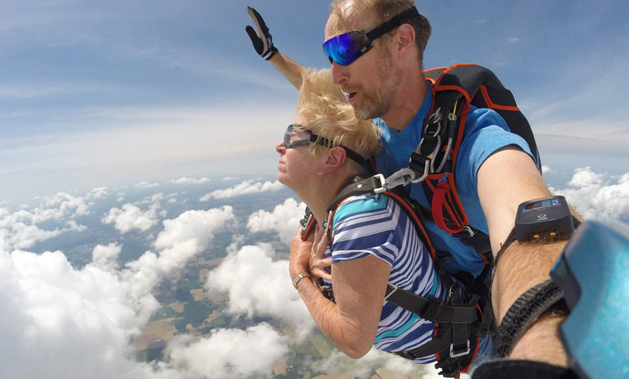 Older woman tandem skydiving with instructor