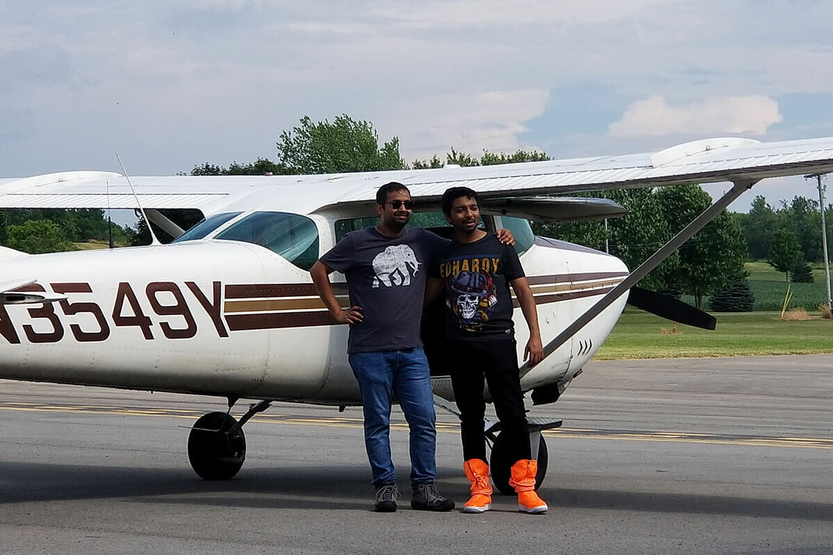 Two male skydivers pose in from of Cessna 182.